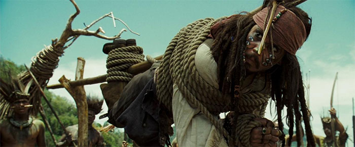 Jack Sparrow tied up to a branch in a scene capturing pirates of the Caribbean adventure and iconic quotes.