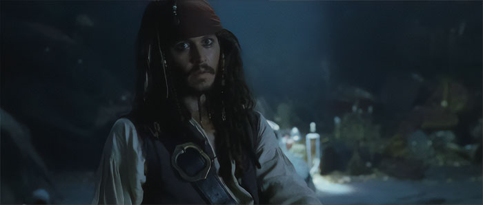 Jack Sparrow in dim light with pirate attire, embodying the spirit of Pirates of the Caribbean quotes and adventure.