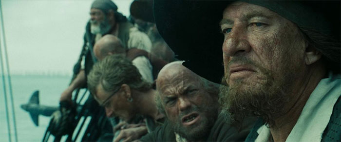Hector Barbossa gazing into the distance on a ship deck in a scene related to Pirates of the Caribbean quotes treasure.