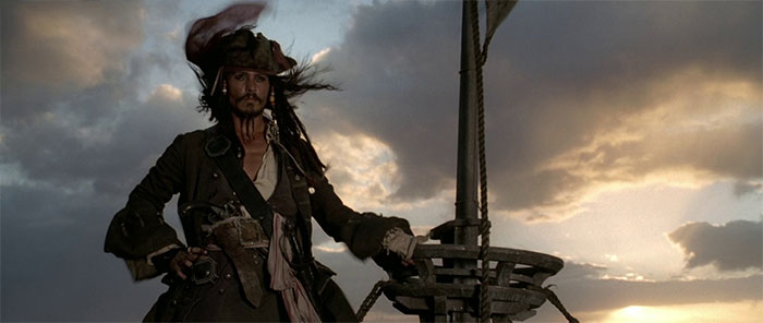 Jack Sparrow standing on top of a ship during sunset, embodying the spirit of Pirates of the Caribbean quotes and adventure.