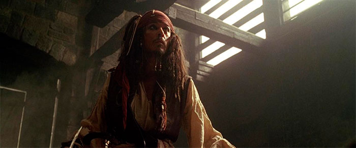 Jack Sparrow standing in a dimly lit room, embodying the spirit of Pirates of the Caribbean quotes and adventure.