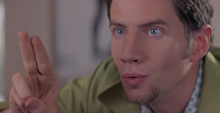 Randy whistling with his two fingers up