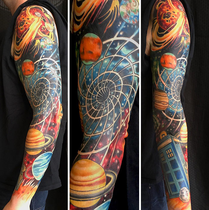Science tattoo featuring planets, a spiral galaxy, and a blue box on a man's arm, highlighting cosmic themes.
