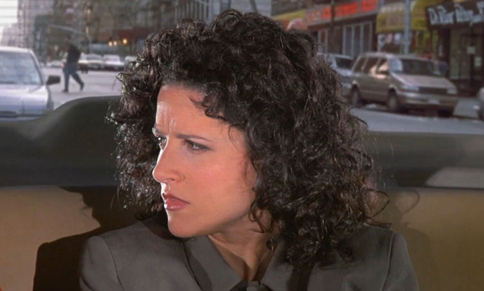 Elaine from Seinfeld looking angry in a gray jacket, capturing one of the funniest Seinfeld quotes moments.