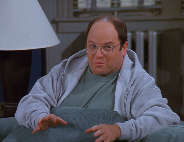 George from Seinfeld wearing a gray hoodie and shirt, capturing one of the funniest Seinfeld quotes about everyday life.