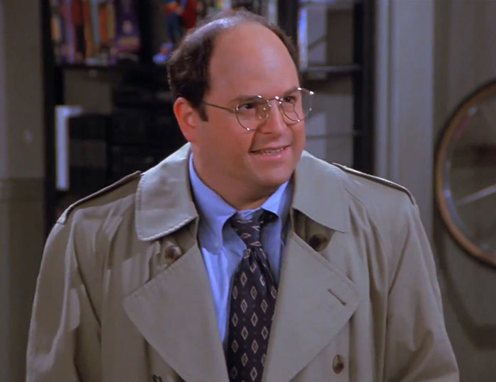 George wearing a gray jacket and blue shirt from Seinfeld, captured in a scene reflecting funniest Seinfeld quotes about everyday life