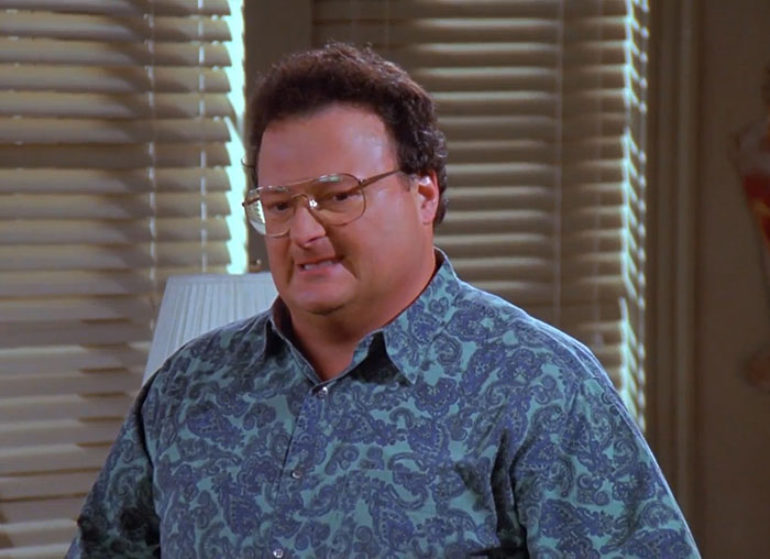 Newman from Seinfeld wearing a patterned blue shirt, capturing one of the funniest Seinfeld quotes about everyday life.