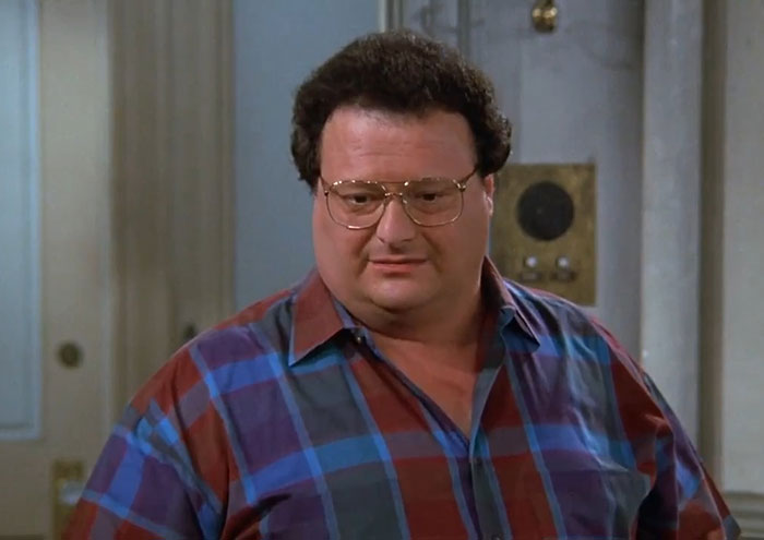 Newman wearing a blue and red shirt, a classic character featured in funniest Seinfeld quotes about everyday life.