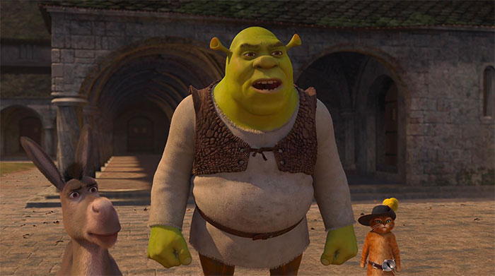 Shrek, Donkey, and Puss in Boots standing together in a medieval village setting from Shrek quotes about the swamp.