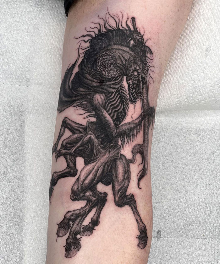 Detailed Bloodborne video game tattoo featuring a mythical creature on leg, showcasing intricate linework.