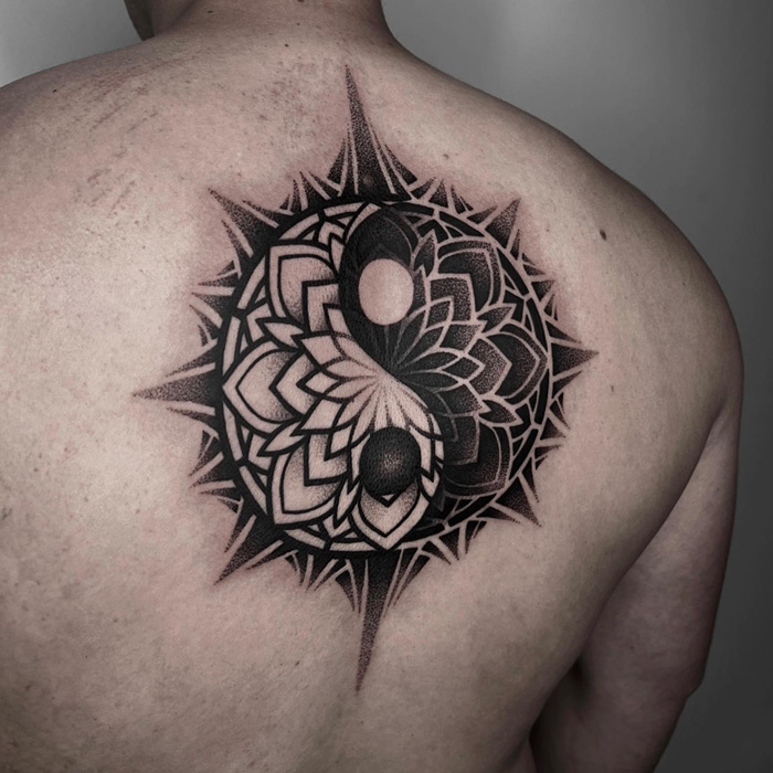 Intricate yin yang tattoo design on upper back symbolizes the duality of life.
