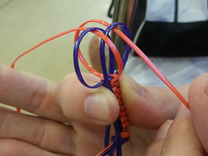 Hands weaving orange and purple bands together, illustrating what eventually disappeared without anyone noticing concept.