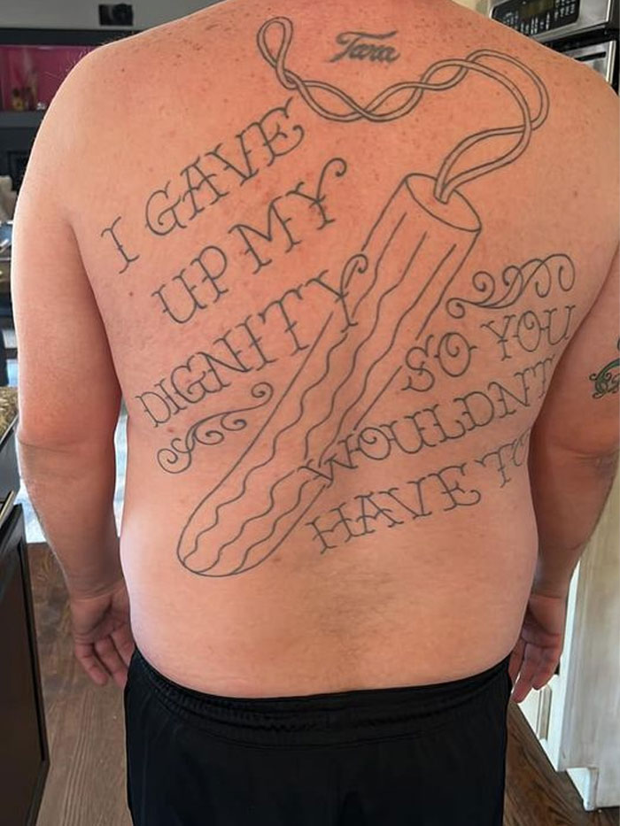 Back tattoo of a large, misspelled design depicting a tampon and humorous text, illustrating a tattoo mistake.