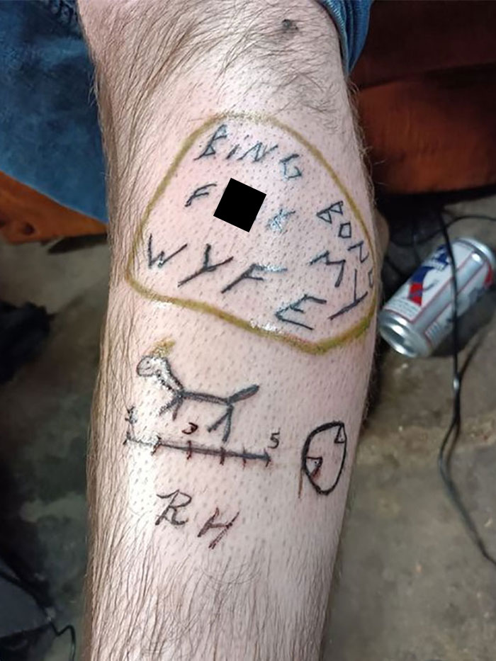 Poorly drawn tattoo on a person's leg, featuring illegible text and crude images, representing a permanent mistake.