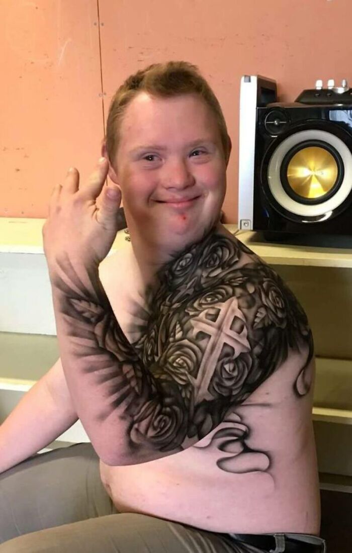 Hospitalized kid showing off a detailed spray-on tattoo on their arm, featuring roses and a cross design.