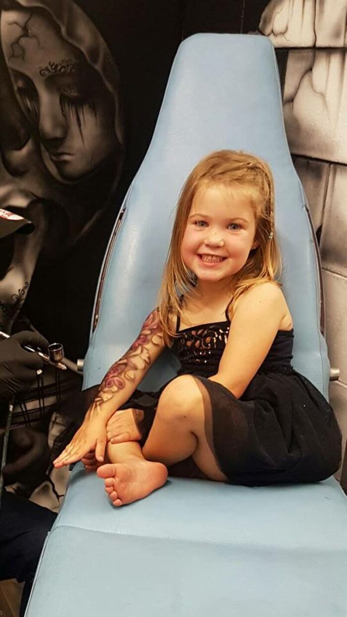 Hospitalized child smiles with spray-on tattoo in a clinic setting.