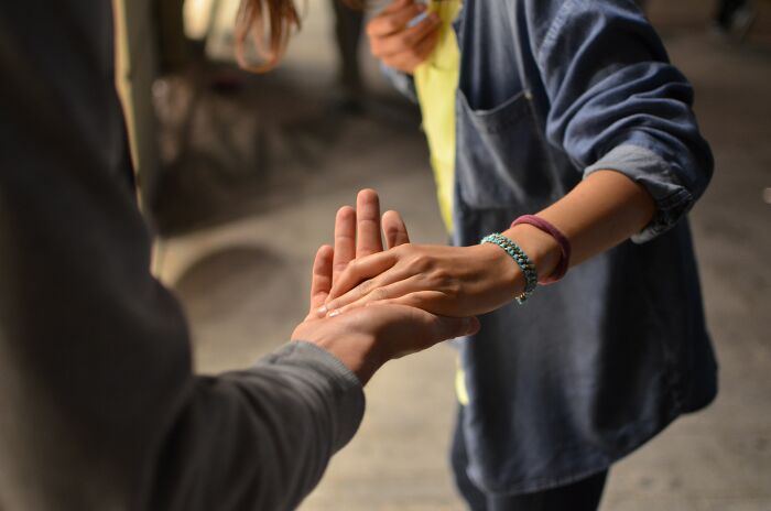 Two people holding hands in a heartfelt moment, symbolizing deep connection and meaningful online group interactions.