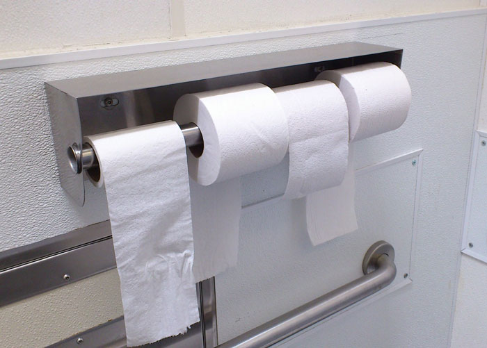 Toilet paper rolls on a holder, emphasizing hygiene in a clean restroom setting.