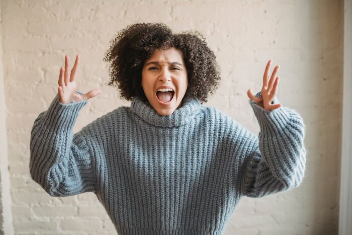 Woman in a gray sweater expressing intense emotion, representing deep things said in an online group discussion.
