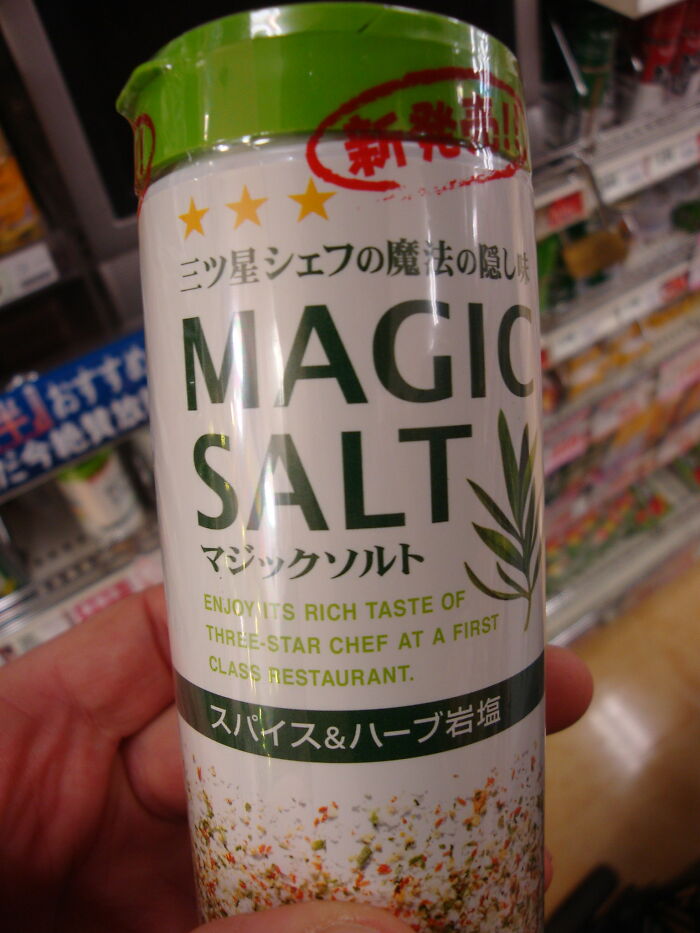 Hand holding a container of magic salt seasoning with spices and herbs in a supermarket aisle, wondering what disappeared.