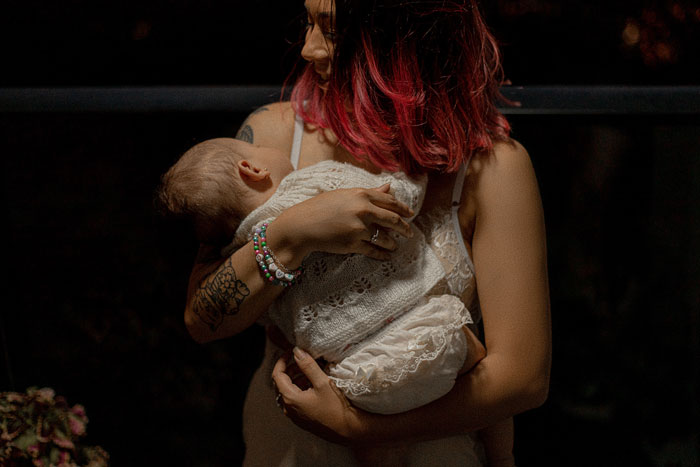 Woman holding baby while speaking in Polish, highlighting a family language dynamic and parenting challenge.