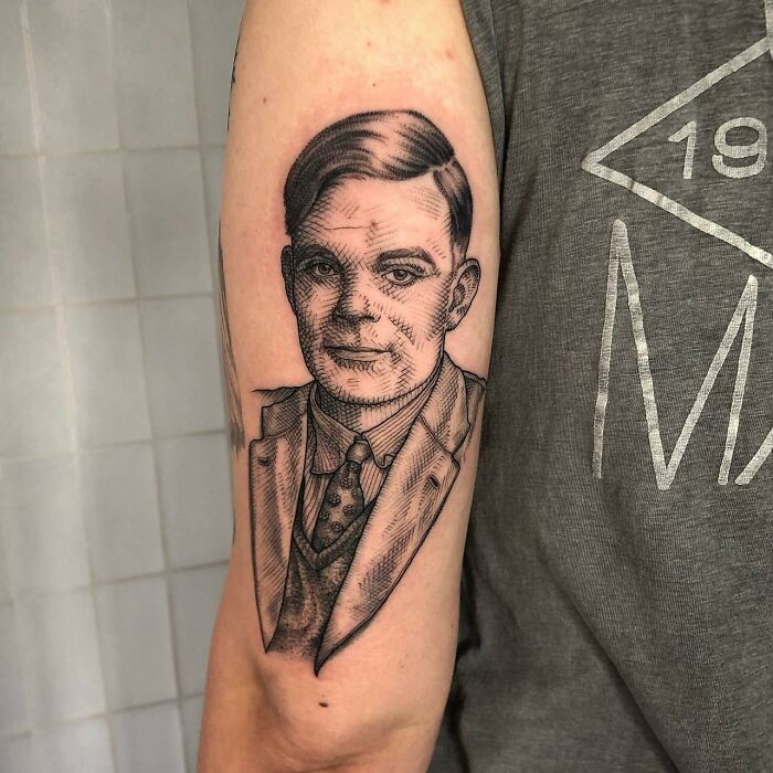 Tattoo of a portrait on an arm, depicting a scientist in a suit and tie, highlighting science tattoos.