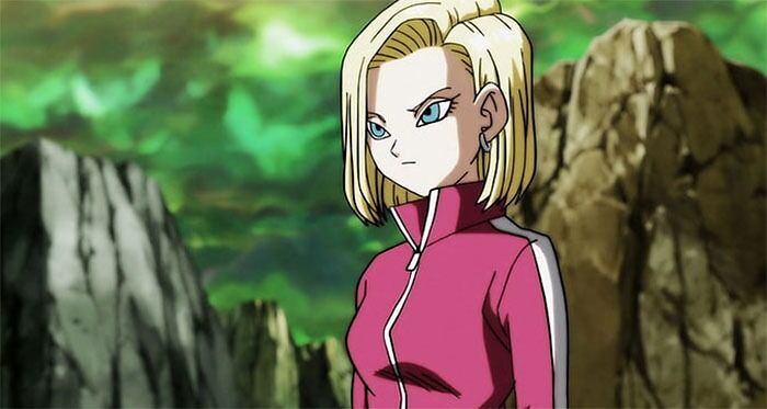 Female anime character with blonde hair and a pink jacket in a rocky landscape.
