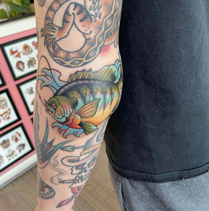 Colorful fish elbow tattoo with vibrant details, emphasizing unique elbow tattoo ideas.