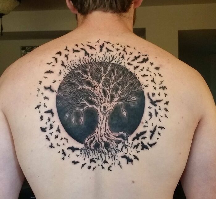 Majestic tree tattoo on back, featuring intricate branches and surrounding birds.
