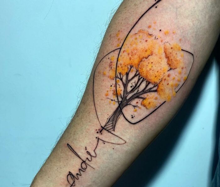 Tattoo of a tree with orange foliage on an arm, showcasing the wonders of nature artistry.