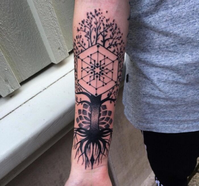 Forearm with a detailed tree tattoo incorporating geometric shapes, celebrating the wonders of nature.
