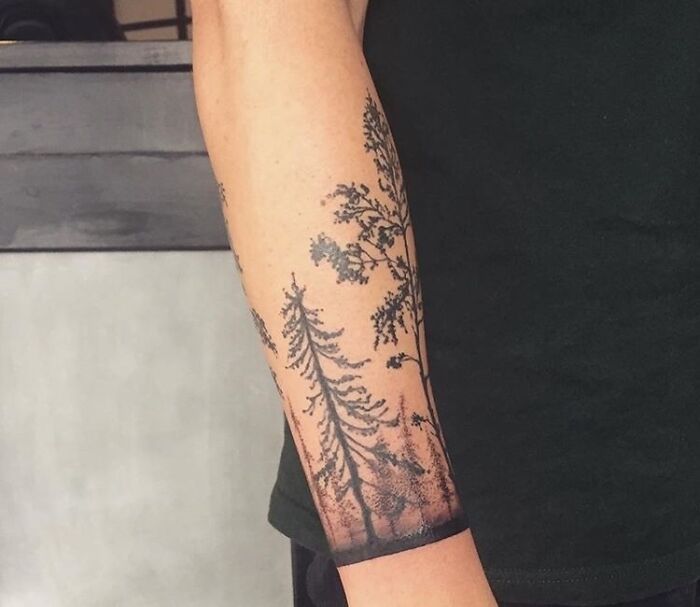 Forearm with a detailed majestic tree tattoo, symbolizing the wonders of nature.