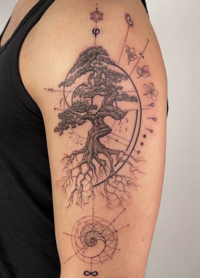 Arm with a tree tattoo featuring geometric designs, highlighting the wonders of nature.