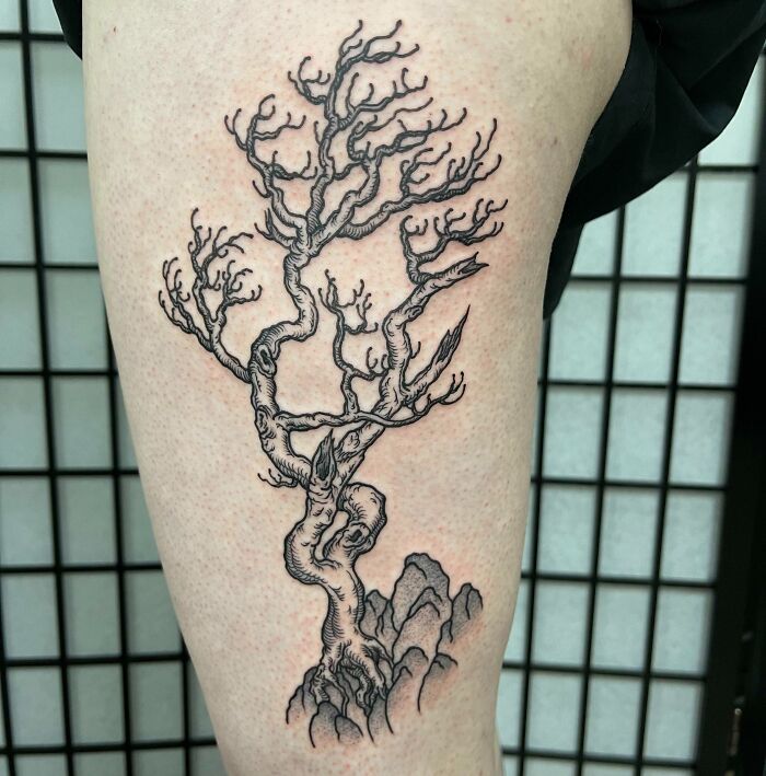 Majestic tree tattoo design on leg, with intricate branches and roots, celebrating nature's wonders.