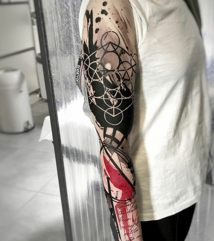 Detailed Trash Polka tattoo featuring abstract black and red designs on an arm.