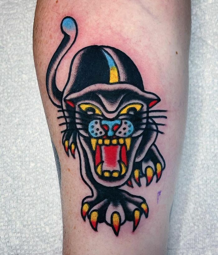 American traditional tattoo design of a fierce black panther on the arm, showcasing bold colors and striking details.