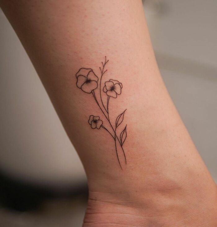 Delicate floral ankle tattoo design with fine line art, perfect inspiration for tattoo care.