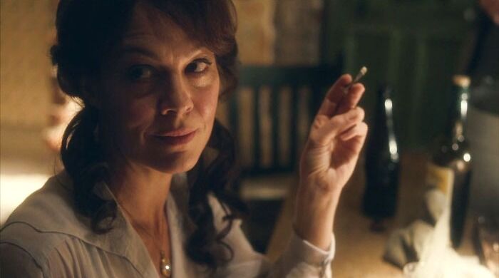 Polly Gray smiling and holding a cigarette