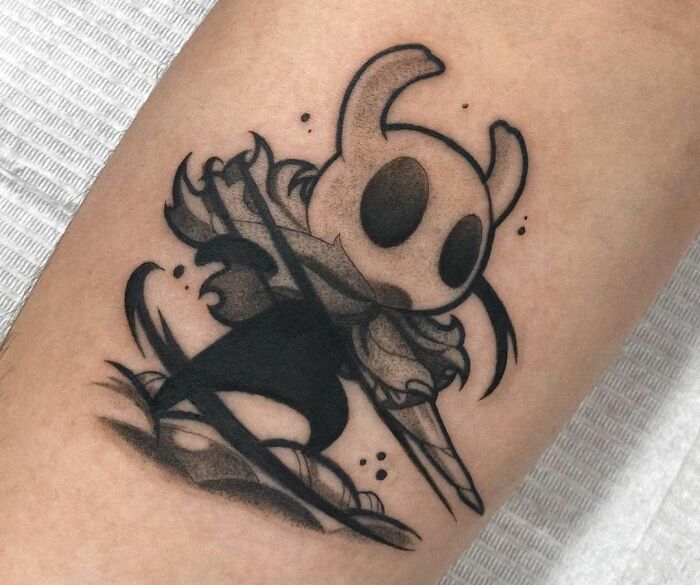 Tattoo of a video game Hollow Knight character in a dynamic pose, perfect for hardcore gamers.