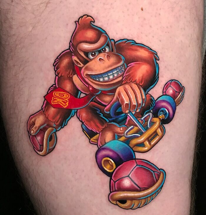 Super Mario video game tattoo featuring a cartoon character driving a go-kart, showing vibrant colors and dynamic design.