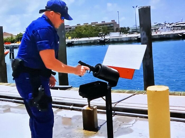 A person examining a mysterious object mounted on a dock near the water, discovering unusual items outdoors.