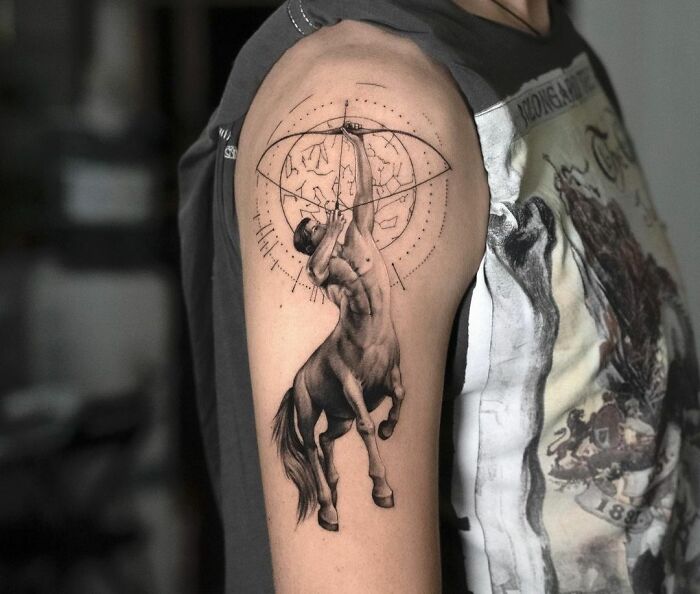 Zodiac tattoo featuring Sagittarius centaur archer on upper arm, showcasing intricate detail and celestial elements.