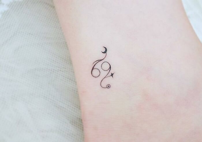 Delicate zodiac tattoo design with moon and star motifs on the skin.