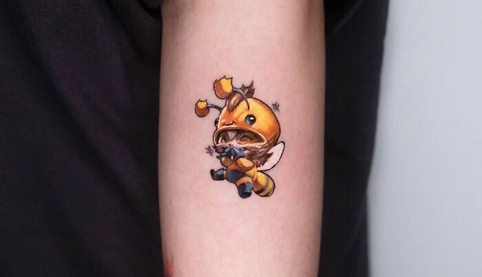 League Of Legends cute video game tattoo of a character in a bee costume on a person's arm, ideal for hardcore gamers.
