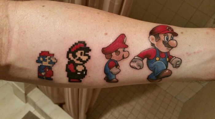 Video game tattoos featuring evolving pixel art Mario characters on a forearm.