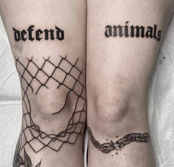 Gothic tattoo on legs with words "defend animals" and chain design.