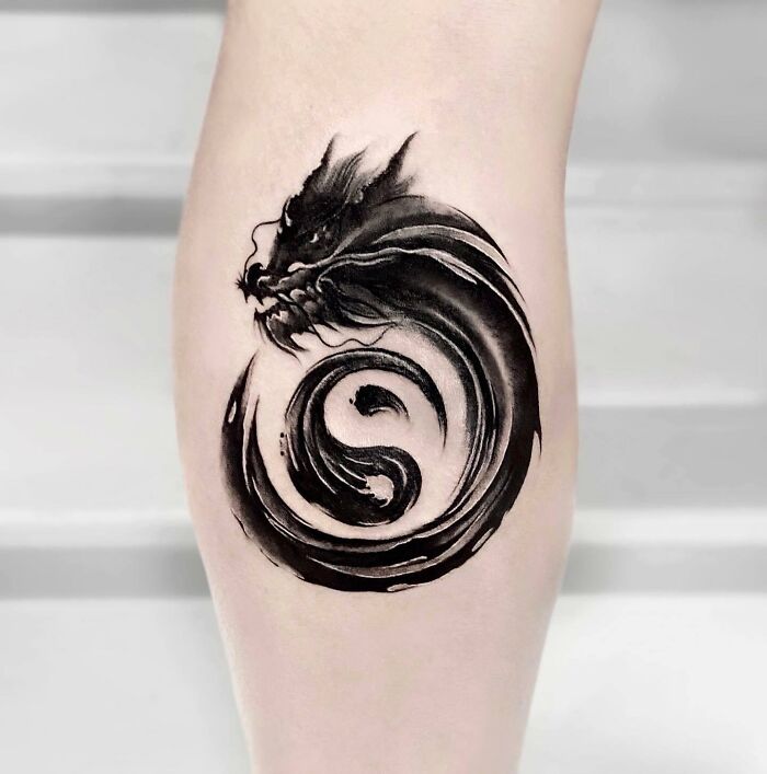 Dragon-themed Yin Yang tattoo on the calf, showcasing the duality of life with intricate black ink detailing.