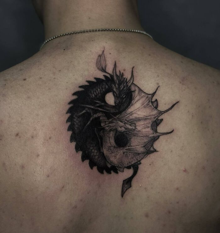 Dragon-themed yin yang tattoo on back representing duality.