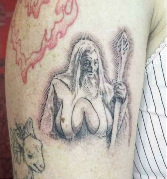Tattoo of a wizard holding a staff with unusual features, highlighting the importance of researching tattoo artists.