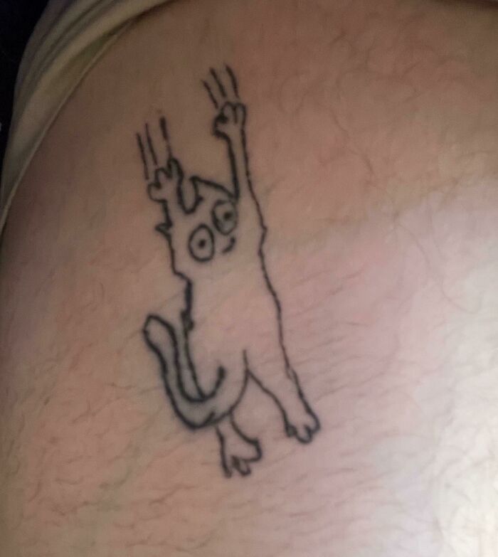 Unusual cat tattoo with claws out, highlighting the need to research tattoo artists better.